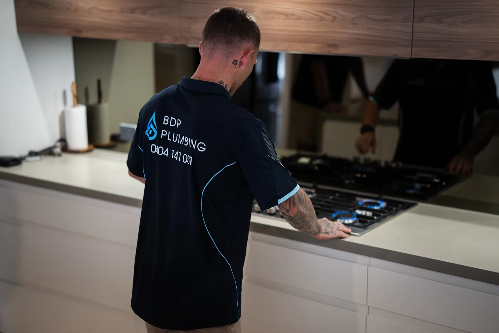 Plumber checking a gas cooktop connection